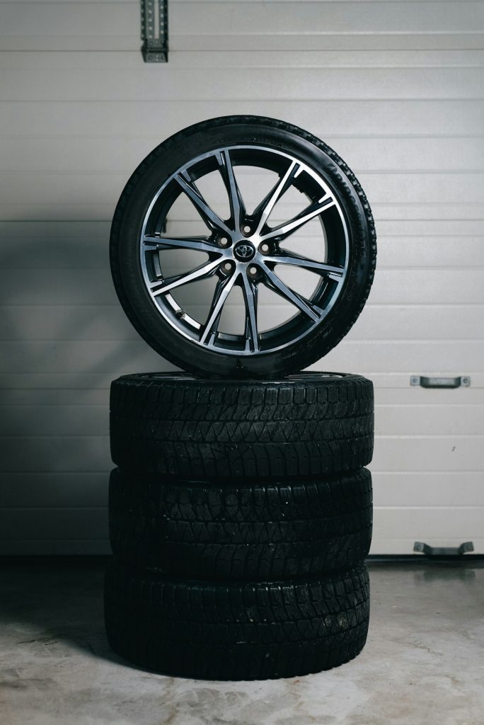 stack-of-car-tires-with-one-alloy-wheel-on-top-y-251qyx55y