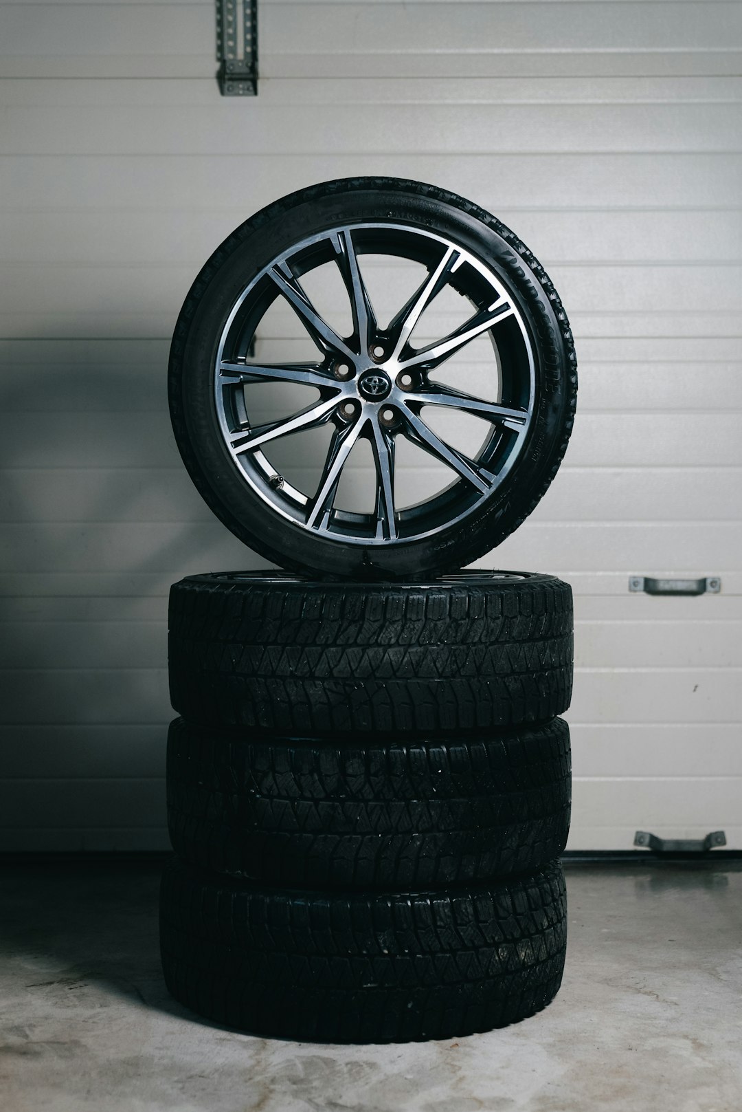 stack-of-car-tires-with-one-alloy-wheel-on-top-y-251qyx55y